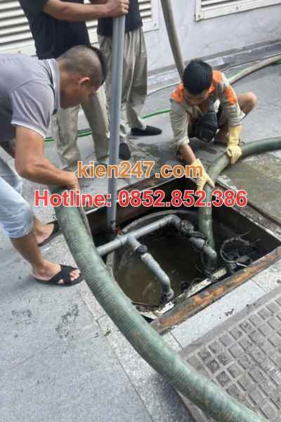 Nhân viên luôn ống hút xuống vị trí bể phốt